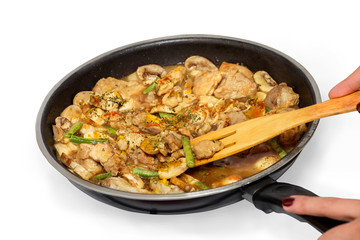 Chief cooking meat in a frying pan isolated