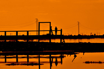 Pareja de novios en un embarcadero al atardecer.