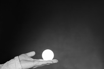 Hand mit Gluehbirne /Hand mit Gluehbirne vor schwarzem Hintergrund mit Textfreiraum.