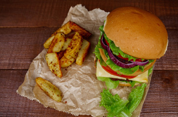 Big burger with fries on wooden