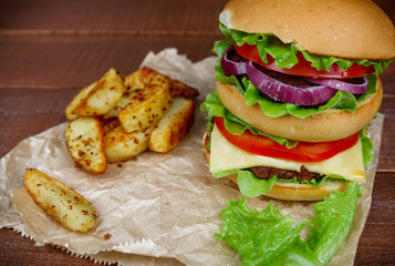 Big burger with fries on wooden