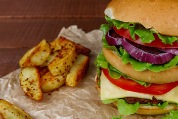 Big burger with fries on wooden