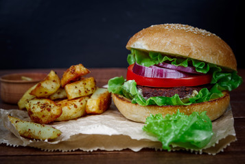 Big burger with fries on dark