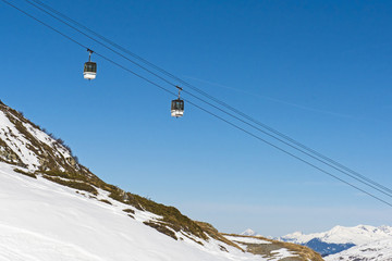 View of an alpine ski slope with cable car lift