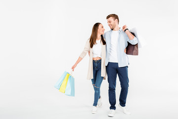 Happy young couple with shopping bags hugging and looking at each other