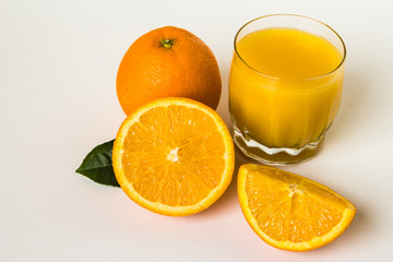 Oranges and glass of juice on a white background.