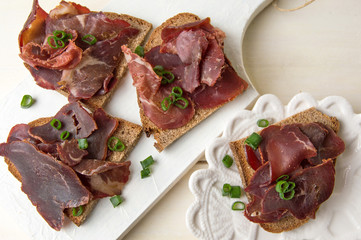 Smoked prosciutto ham on bread slices