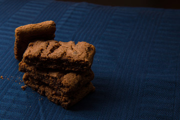 Chocolate cookies on blue linen napkin. Chocolate chip cookies shot on coffee colored cloth, closeup.