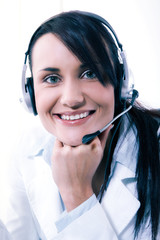 Female call center service operator at work. Attractive female helpdesk employee with headset at workplace