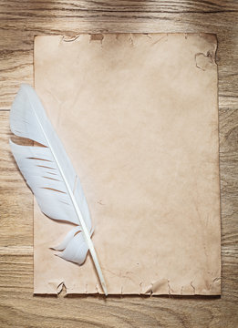 Vintage sheet of paper quill on wooden board