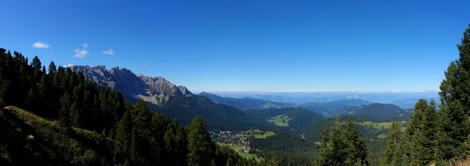 Fototapeta na wymiar Traumhafte Panorama Aussicht ins Tal auf Wiesen und Wälder / Rosengarten / Südtirol
