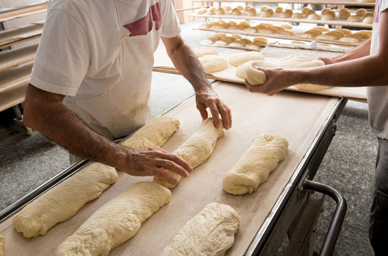 Bakers Putting Bread To A Band For Oven