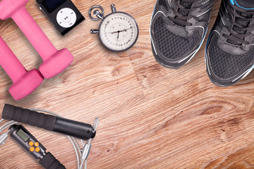 Fitness gym and running equipment. Stopwatch and running shoes, jumping rope and music player. Time...