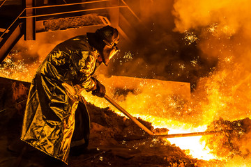 Worker metallurgist working in the domain shop, industrial background