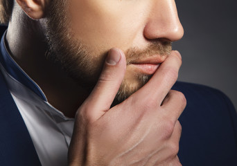Close-up part of face of man with beard and hand