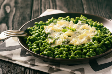 German dumplings (spaetzle) with spinach and cheese sauce.