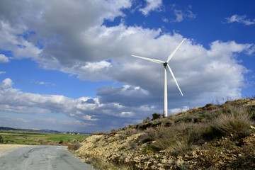 Landscape with cloudy sky and details of a windmill