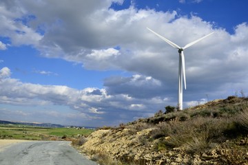 Landscape with cloudy sky and details of a windmill