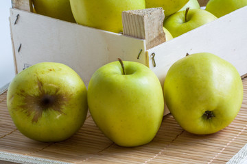 Pommes Golden en tas  dans un cageot sur fond de bambou