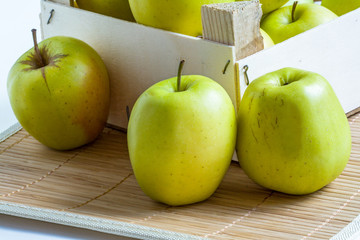 Pommes Golden en tas  dans un cageot sur fond de bambou
