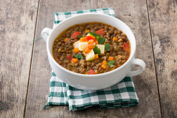 Lentil soup in a bowl on wooden background
