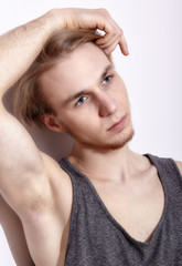 Young blonde man in shirt posing
