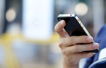 Hand holding mobile smart phone, telephone with blur background