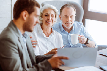 Positive aged couple meeting with insurance agent
