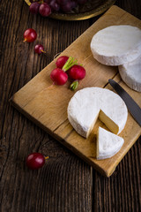 Cheese with white mold, grapes and radish
