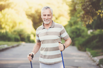 Obraz premium Joyful pleasant man using poles