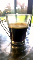 Long coffee by the green garden during a cold day