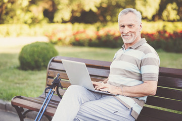 Obraz premium Cheerful senior man working on a laptop