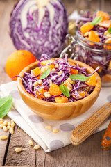 Red cabbage tangerines and pine nuts salad. Selective focus. Copy space.