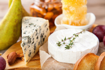 Cheese, honey and fruit on a table. Selective focus. Copy space.