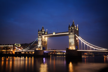 the iconic Tower Bridge of London lit up at night over the River Thames