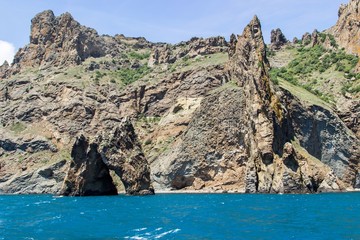 Fototapeta na wymiar Rocky coastline of south Crimea. View from the sea: golden gates of Karadag