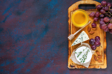 Cheese, honey and fruit on a table. Selective focus. Top view. Copy space.