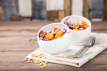 Red cabbage tangerines and pine nuts salad. Selective focus. Copy space.