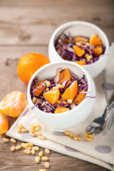 Red cabbage tangerines and pine nuts salad. Selective focus. Copy space.