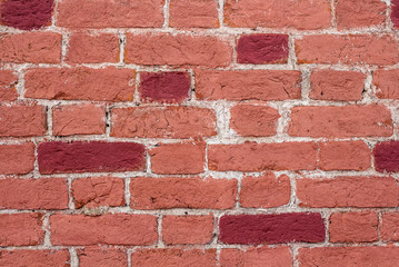 Obraz premium The wall of red brick. Some bricks are painted crimson red.