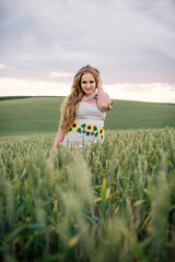 Young girl at ukrainian national dress posed at wreath field.