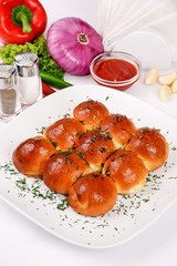 Dumplings with garlic on a white plate decorated with dill, on a background of vegetables