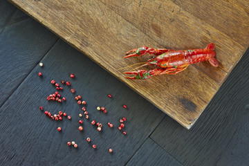 Crayfish with red pepper. Delicious, boiled, red crawfish on a wooden cutting board, close-up.