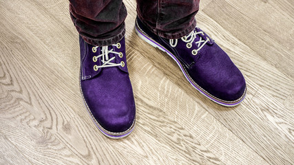 Close up view on man's legs in dark jeans and leather boots