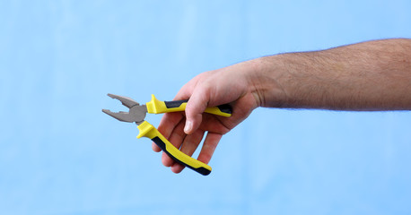 hands holding construction tools,  pliers
