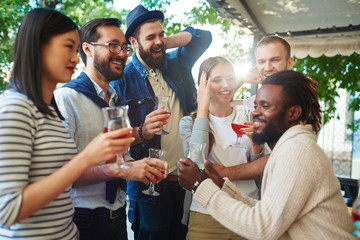 Intercultural buddies with drinks enjoying celebration