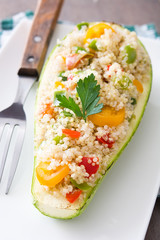 Stuffed zucchini with quinoa and vegetables on wooden background
