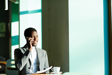 African-american trader speaking to client by cellphone