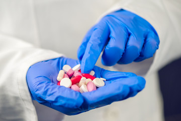 Female doctor hand full of various pills and medications