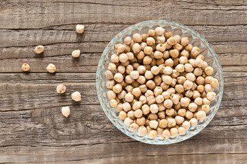 Kichererbsen in einer Glasschüssel auf einem Holztisch